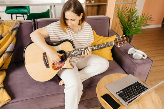 Woman learn guitar through online training at home