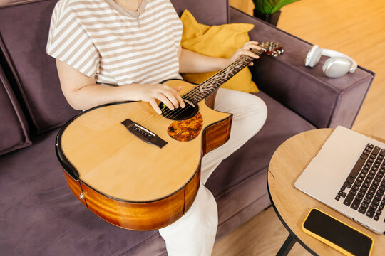 Woman learn guitar at home with online training