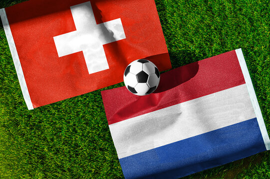 Switzerland vs. Netherlands football match. National flags on green grass with soccer ball in the middle. Football background for international match.