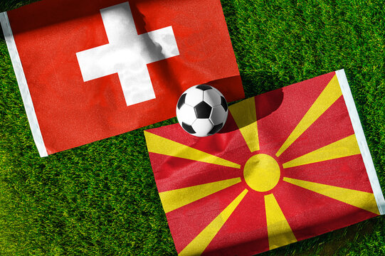 Switzerland vs. North Macedonia football match. National flags on green grass with soccer ball in the middle. Football background for international match.