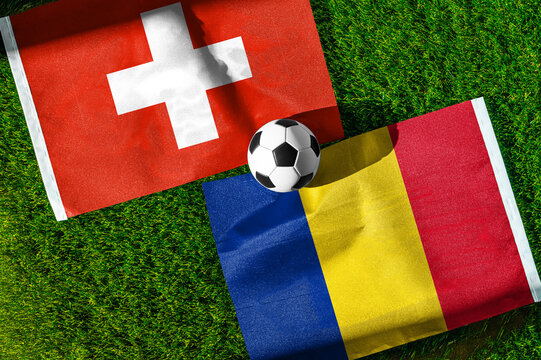 Switzerland vs. Romania football match. National flags on green grass with soccer ball in the middle. Football background for international match.