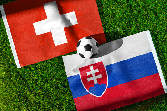 Switzerland vs. Slovakia football match. National flags on green grass with soccer ball in the middle. Football background for international match.