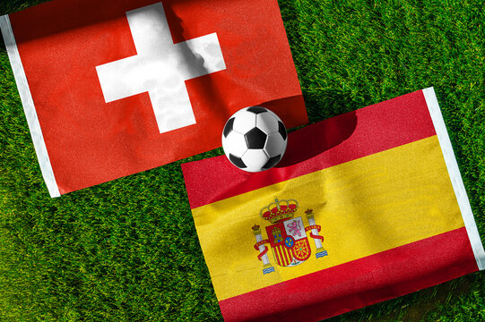 Switzerland vs. Spain football match. National flags on green grass with soccer ball in the middle. Football background for international match.