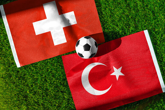 Switzerland vs. Turkey football match. National flags on green grass with soccer ball in the middle. Football background for international match.