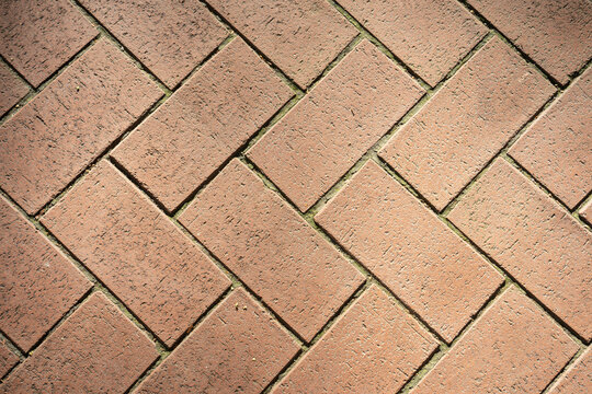 Red clay brick paving herringbone pattern floor texture background