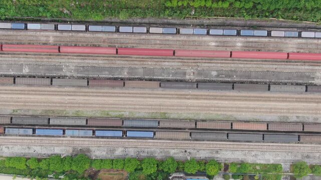 Aerial View of Multiple Freight Trains on Parallel Railway Tracks with Colorful Cargo Cars