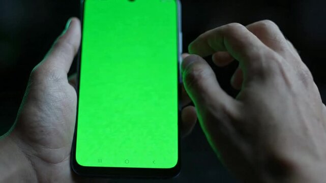 Close-up of hands using smartphone with green screen chroma key display for app ui mockup mobile app