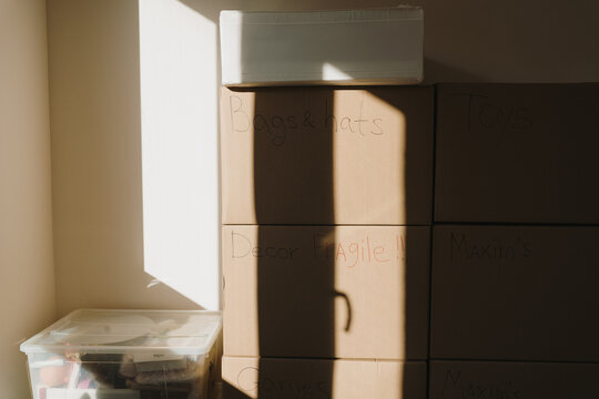 Interior View Of Room Packed Full Of Cardboard Moving Boxes And Belongings