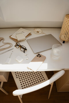 Top View Modern Workspace Essentials On White Desk With Chair
