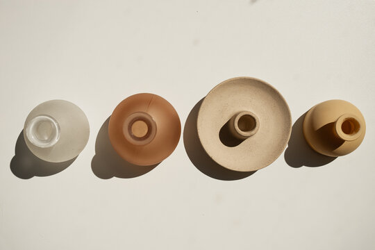 Horizontal Flat Lay Of Four Small Ceramic Vases With Hard Sun Shadow