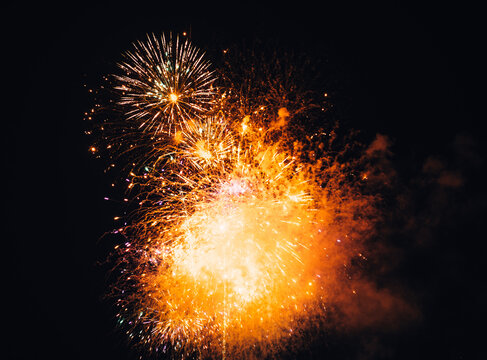 Brightly colored fireworks exploding in the night sky with a