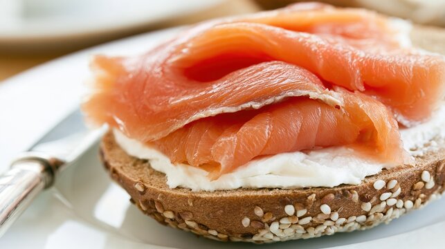 bagel. Close-up of sliced smoked salmon on a cream cheese bagel with a silver knife beside it. menu design, packaging mockups, designed for food delivery and cloud-kitchen brand materials.