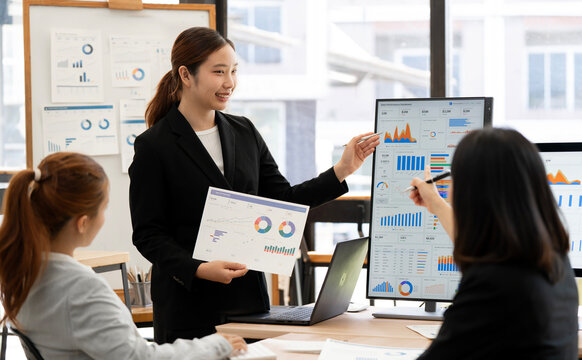 Asian Businesswoman Presenting Financial Growth Report to Team