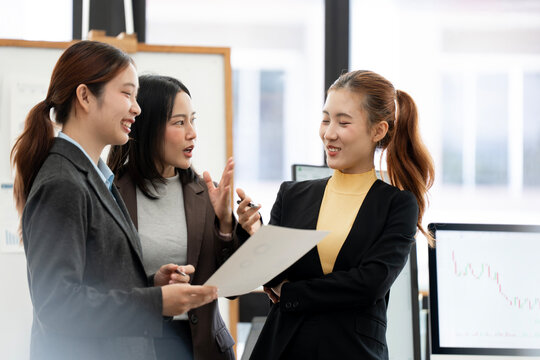 Asian Business Women Reviewing Document and Discussing Strategy