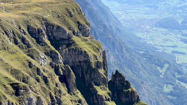 Dramatic view from Ch&auml;serrugg over steep cliffs toward Walenstadt, Flums and the Seez Valley in Switzerland, revealing the extreme drop and rugged terrain of the Churfirsten mountains.
