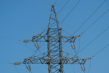 High voltage power line tower stands against clear blue sky in the afternoon © beholdereye