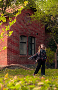 autumn cottage core aesthetic vibe of dancing woman in October back yard of village space vertical photography