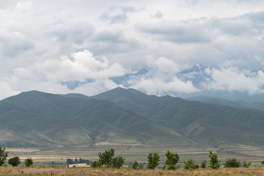  Mountain valley landscape under dramatic clouds. Natural mountain landscape in Kyrgyzstan.