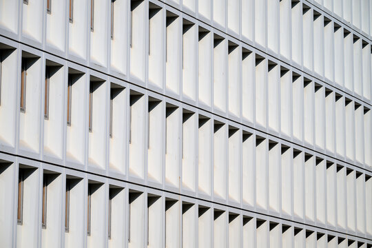 Close-up of the concrete facade of a modern building with many windows.