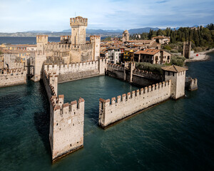 Ancient stone castle with rectangular towers on lake shore on sunny day, Sirmione, Lake Garda, Italy © Igor