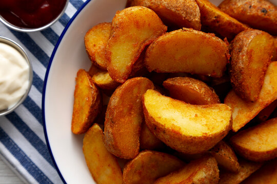 Homemade Potato Wedges with Ketchup and Mayonnaise, top view.