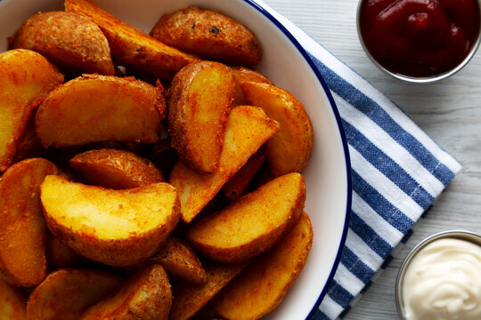 Homemade Potato Wedges with Ketchup and Mayonnaise, top view.
