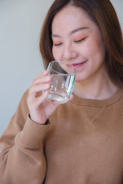 Vertical portrait image of a woman holding and drinking water