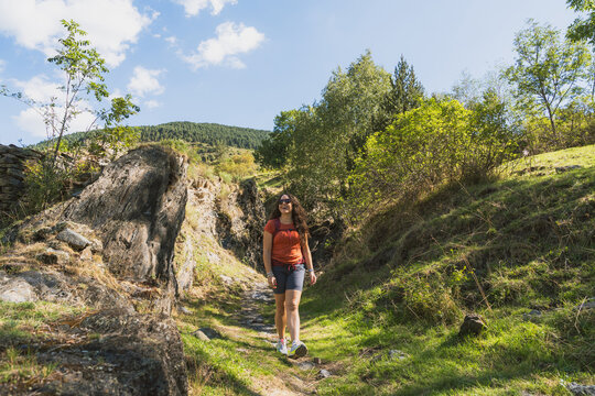 Woman hiking mountain trail enjoying sunny day