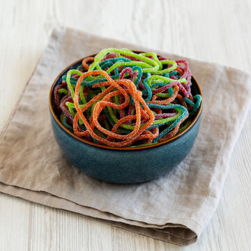 Colorful Spaghetti Jelly Candies Sprinkled with Sugar in a Bowl, side view.