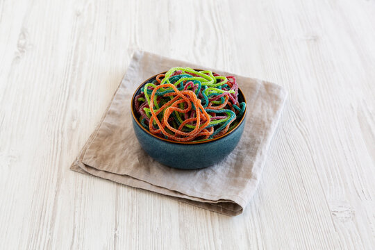 Colorful Spaghetti Jelly Candies Sprinkled with Sugar in a Bowl, side view.