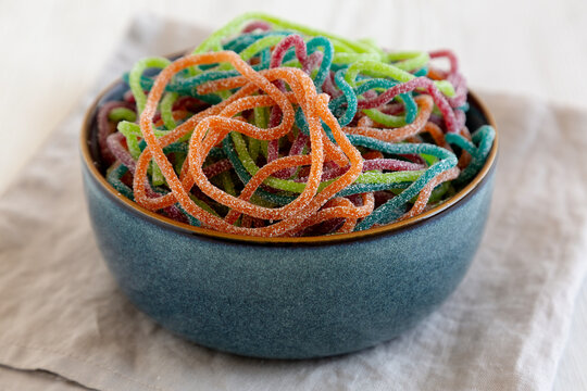 Colorful Spaghetti Jelly Candies Sprinkled with Sugar in a Bowl, side view.