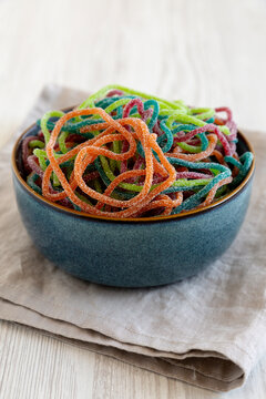 Colorful Spaghetti Jelly Candies Sprinkled with Sugar in a Bowl, side view.