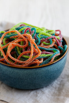 Colorful Spaghetti Jelly Candies Sprinkled with Sugar in a Bowl, side view.