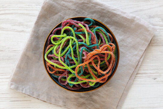 Colorful Spaghetti Jelly Candies Sprinkled with Sugar in a Bowl, top view.