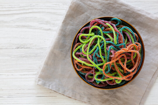 Colorful Spaghetti Jelly Candies Sprinkled with Sugar in a Bowl, top view. Copy space.