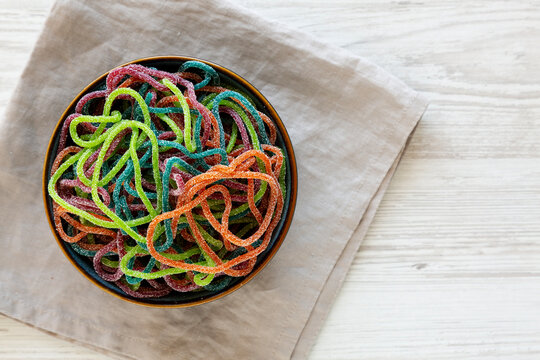 Colorful Spaghetti Jelly Candies Sprinkled with Sugar in a Bowl, top view. Copy space.