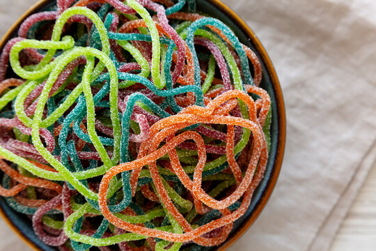 Colorful Spaghetti Jelly Candies Sprinkled with Sugar in a Bowl, top view. Close-up.