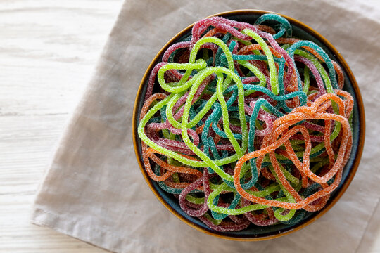 Colorful Spaghetti Jelly Candies Sprinkled with Sugar in a Bowl, top view. Copy space.