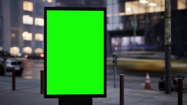 Vertical green screen citylight sign on an urban avenue in soft early morning light, wet streets after rain. Time lapse of city traffic, bokeh lights and moving cars. Clean chroma key area for