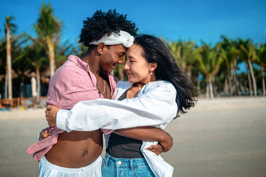 Carefree couple enjoying a tropical beach vacation, laughing making unforgettable memories together