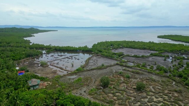 Aerial panorama of the rural Bicol landscape near Lagay, Calauag, Camarines Sur, showing expansive green farmland, tropical trees, waterways and countryside settlements stretching toward the water.