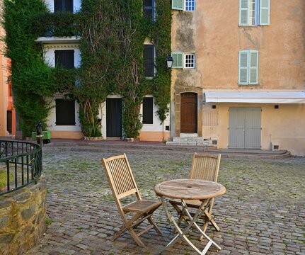 Proven&ccedil;al style houses cul-de-sac with wooden bistro furniture in Saint-Tropez, French Riviera France.