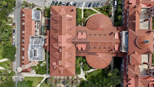 Aerial view of the historic Lightner Museum featuring its distinctive red tile roofs, ornate domes, and surrounding lush greenery in St. Augustine, Florida, United States.