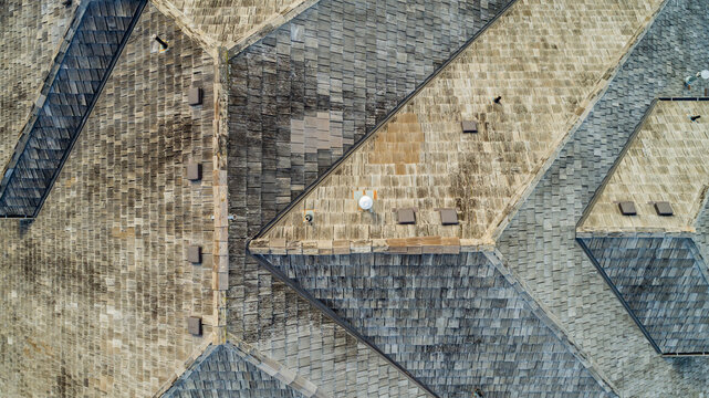 Aerial view of the weathered wooden shingle roof of a residential house on Ridgeview Lane, featuring complex geometric angles and roof vents in Lake Oswego, Oregon, United States.