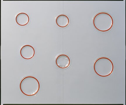 Brass gold pipe rings floating on pewter grey water, a serene study of home heating parts with soft ripples for winter energy maintenance