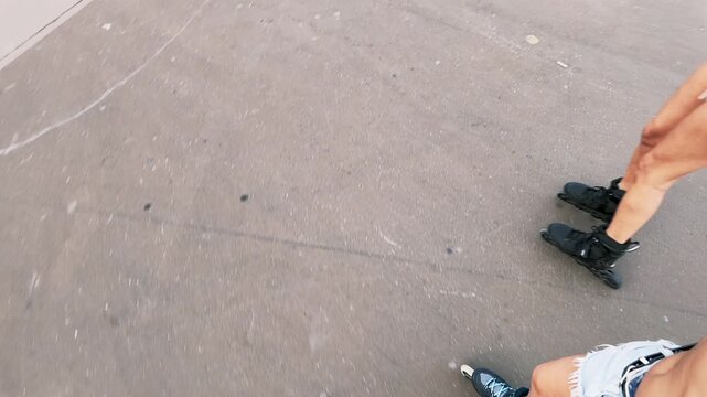 Two cheerful young women rollerskating and taking a selfie video