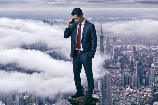 Businessman talking on the phone with cityscape and clouds in the background