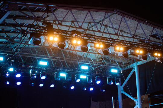Bright concert stage lights under roof at night