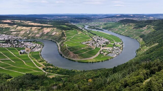 Spektakul&auml;re Luftaufnahme der Moselschleife bei P&ouml;lich und Mehring. Gr&uuml;ne Weinberge s&auml;umen das tiefblaue Flussufer unter leicht bew&ouml;lktem Sommerhimmel in der Urlaubsregion Mosel.