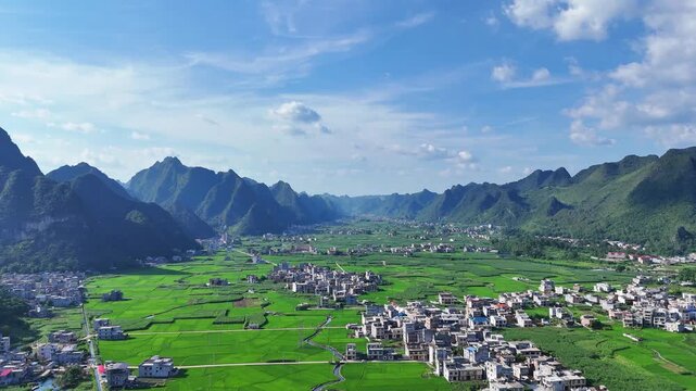 Landscape view: Expansive valley plain with dense village settlements and patchwork green farmlands